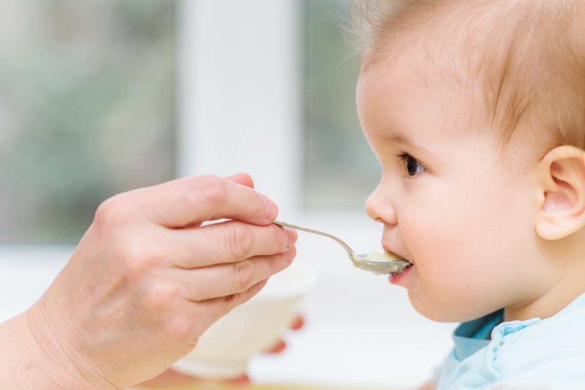 grandmother gives baby food from a spoon